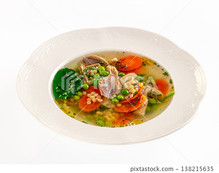 Gourmet chicken soup with fresh vegetables and pasta in a white ceramic bowl on a white background 138215635