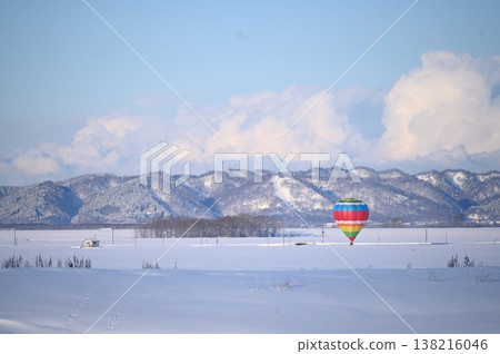 Hot air balloons floating over a snowfield Hot air balloons floating over a snowfield 138216046