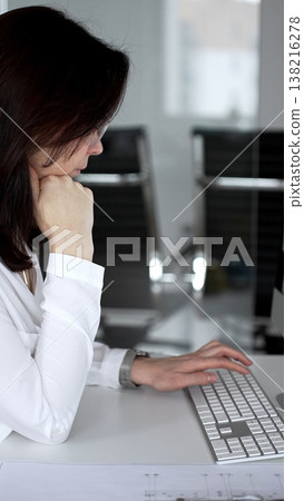 Woman architect analyzing construction blueprint on computer screen in modern design office, planning new building project. Business and architecture concept 138216278