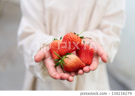 A child holding a strawberry 138216279