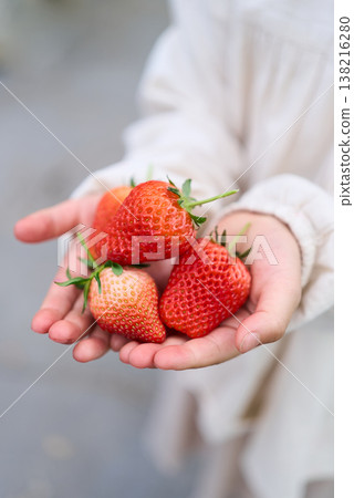 A child holding a strawberry A child holding a strawberry 138216280