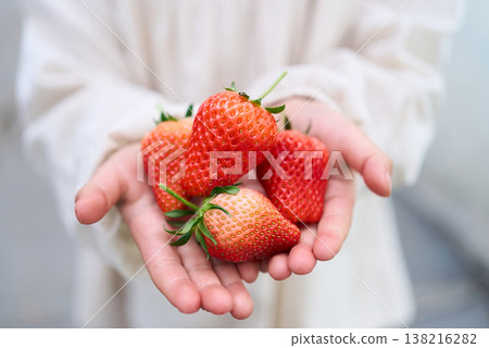 A child holding a strawberry A child holding a strawberry 138216282