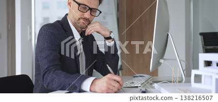 Architect man thinking while working on blueprints and computer, planning new building design in office. Business and architecture concept Architect man thinking while working on blueprints and computer, planning new building design in office. Business and architecture concept 138216507