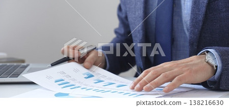 Businessman analyzing financial charts on laptop, reviewing data for strategic business planning and investment optimization. Business people concept Businessman analyzing financial charts on laptop, reviewing data for strategic business planning and investment optimization. Business people concept 138216630