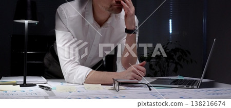 Stressed businessman suffering from overwhelming burnout and work overload, working late into the night, feeling frustrated with deadline pressure in a dark office environment Stressed businessman suffering from overwhelming burnout and work overload, working late into the night, feeling frustrated with deadline pressure in a dark office environment 138216674
