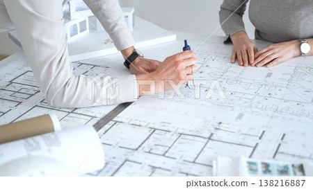 Architects collaborating on building plans, discussing residential project blueprints, developing architectural model, planning future construction design, engineering new housing concepts, close up Architects collaborating on building plans, discussing residential project blueprints, developing architectural model, planning future construction design, engineering new housing concepts, close up 138216887