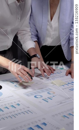 Business professionals analyzing financial data and marketing reports on a white desk, collaborating on project strategy and reviewing company performance with charts and diagrams Business professionals analyzing financial data and marketing reports on a white desk, collaborating on project strategy and reviewing company performance with charts and diagrams 138216909