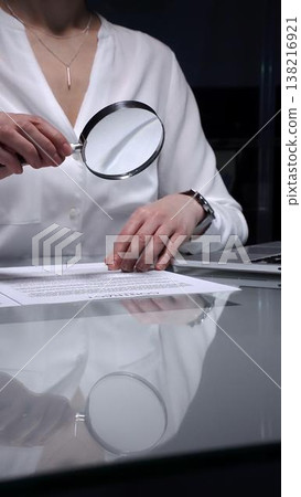 Woman analyzing contract text with magnifying glass, scrutinizing fine print for legal details and agreement review. Audit, business and overworking concepts Woman analyzing contract text with magnifying glass, scrutinizing fine print for legal details and agreement review. Audit, business and overworking concepts 138216921