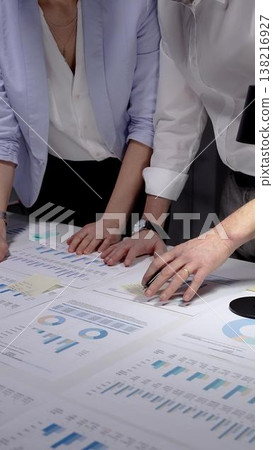 Business professionals analyzing financial data and marketing reports on a white desk, collaborating on project strategy and reviewing company performance with charts and diagrams Business professionals analyzing financial data and marketing reports on a white desk, collaborating on project strategy and reviewing company performance with charts and diagrams 138216927