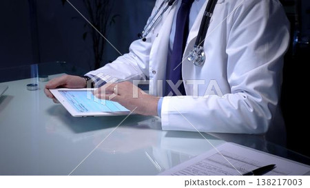 Medical doctor analyzing digital health records on a tablet computer, ensuring patient data management and secure care information in a modern clinic setting Medical doctor analyzing digital health records on a tablet computer, ensuring patient data management and secure care information in a modern clinic setting 138217003