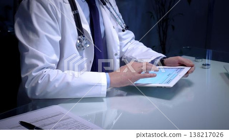 Medical doctor analyzing digital health records on a tablet computer, ensuring patient data management and secure care information in a modern clinic setting 138217026