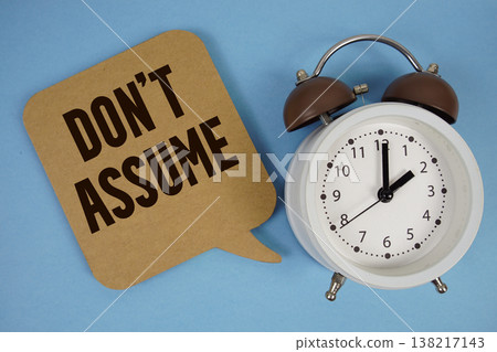Don't Assume text with alarm clock on blue background Don't Assume text with alarm clock on blue background 138217143