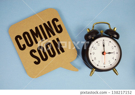 Coming Soon text with alarm clock on blue background Coming Soon text with alarm clock on blue background 138217152