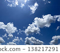 Many large white clouds floating in the blue sky on a beautifully sunny day. 138217291
