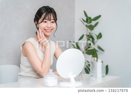 Young Asian woman looking in the mirror and doing beauty, skin care, facial care Young Asian woman looking in the mirror and doing beauty, skin care, facial care 138217878