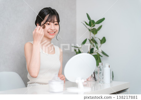 Asian woman applying makeup with cheek brush and face brush Asian woman applying makeup with cheek brush and face brush 138217881