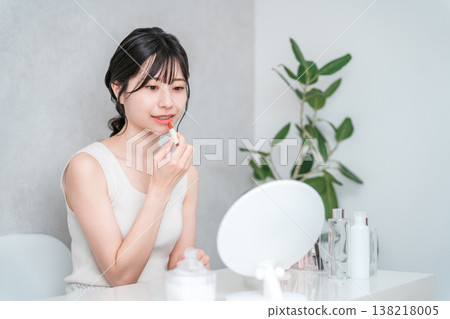 Young Asian woman applying make-up (lipstick, rouge, gloss, lips) 138218005
