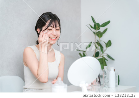 Young Asian woman applying eyeshadow while applying makeup Young Asian woman applying eyeshadow while applying makeup 138218122