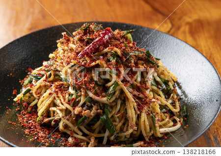 一道辣味麵條,上面撒有紅辣椒和蔥花。這是一道立體感十足、充滿亞洲風味的炒麵。 一道辣味麵條,上面撒有紅辣椒和蔥花。這是一道立體感十足、充滿亞洲風味的炒麵。 138218166
