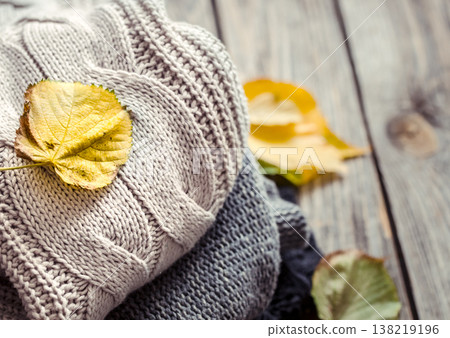 a stack of sweaters and autumn leaves a stack of sweaters and autumn leaves 138219196