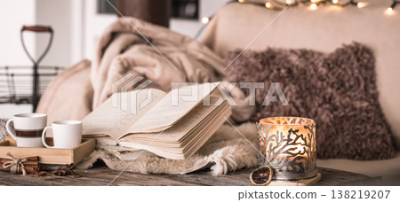 still life home atmosphere in the interior with cups, a book and candles, on the background of cozy bedspreads still life home atmosphere in the interior with cups, a book and candles, on the background of cozy bedspreads 138219207