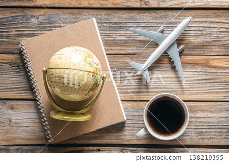 Travel composition with notepad, globe, airplane model and coffee cup, top view. 138219395