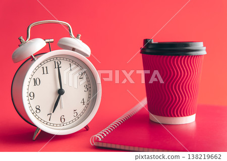 White alarm clock, paper cup and notepad on a blurred background. 138219662
