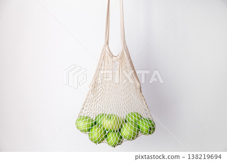 White string bag with green apples on a white background. 138219694