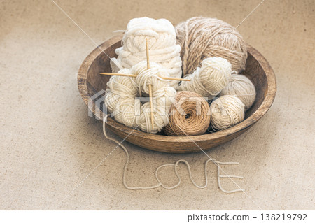 Wooden bowl with threads for knitting yarns close-up. 138219792