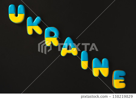 The word Ukraine on a black background, made with handmade gingerbread. The word Ukraine on a black background, made with handmade gingerbread. 138219829