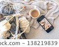 Yarn threads, knitted elements and a cup of coffee, top view. 138219839