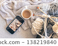 Yarn threads, knitted elements and a cup of coffee, top view. 138219840