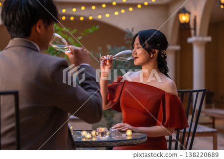 一對新人穿著晚宴婚禮禮服，在晚餐時喝香檳。 138220689