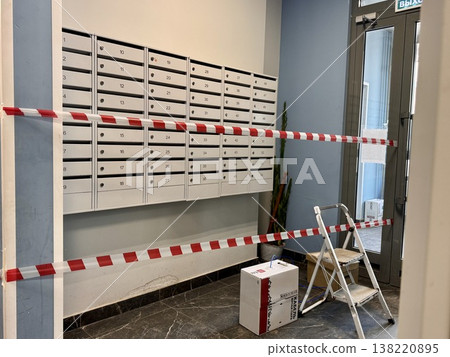 renovation work in the entrance of a multi-storey new building, the territory is fenced with tape 138220895