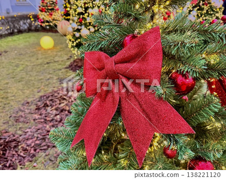 New Year's trees decorated with colorful bright red and white balls, red bows and garlands decorate the territory of the Sklifosovsky Research Institute. New Year's trees decorated with colorful bright red and white balls, red bows and garlands decorate the territory of the Sklifosovsky Research Institute. 138221120