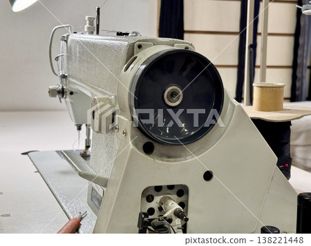sewing workshop with a work area sewing machine filled with threads and working tools 138221448