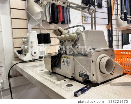 sewing workshop with a work area sewing machine filled with threads and working tools sewing workshop with a work area sewing machine filled with threads and working tools 138221570