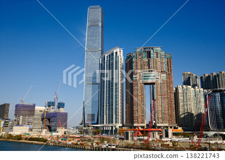 Modern skyscraper towers of West Kowloon district against blue sky in Hong Kong cityscape Modern skyscraper towers of West Kowloon district against blue sky in Hong Kong cityscape 138221743