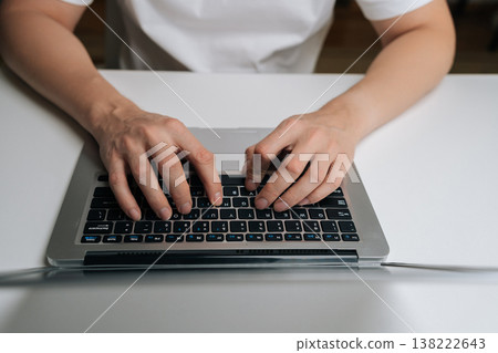 Close-up of male hands typing on laptop keyboard, working remotely from home, connecting online, processing data, coding, managing business, browsing internet, digital communication. 138222643
