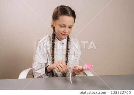 Pretty young girl with braided hair holding heart shaped candy, embodying sweetness and simple happiness during her childhood years, perfect for themes of joy and innocence. Pretty young girl with braided hair holding heart shaped candy, embodying sweetness and simple happiness during her childhood years, perfect for themes of joy and innocence. 138222700