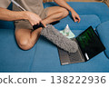Close-up hand of person cleaning laptop keyboard with duster, removing dust and debris for hygiene, ensuring device maintenance and clean home office, providing care for personal electronics. 138222936