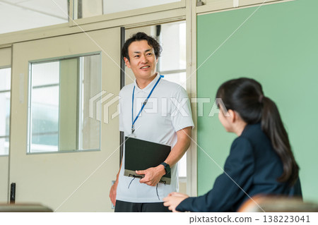 一位身穿 Polo 衫的中年男老師走進教室 一位身穿 Polo 衫的中年男老師走進教室 138223041