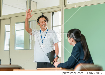 一位身穿 Polo 衫的中年男老師走進教室 一位身穿 Polo 衫的中年男老師走進教室 138223042