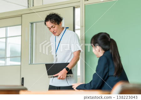 一位身穿 Polo 衫的中年男老師走進教室 一位身穿 Polo 衫的中年男老師走進教室 138223043