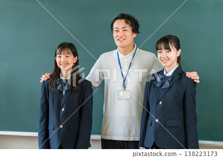教室黑板前,一位男老師和一群小學、國中和高中的女生 教室黑板前,一位男老師和一群小學、國中和高中的女生 138223173