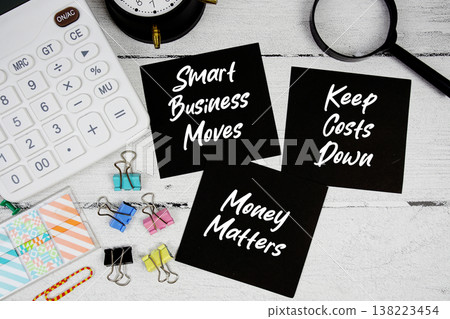 Smart Business Moves, Keep Costs Down, Money Matters text written on paper note with calculator and magnifying glass on wooden background Smart Business Moves, Keep Costs Down, Money Matters text written on paper note with calculator and magnifying glass on wooden background 138223454