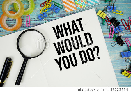 What Would You Do? text on a paper surrounded by office supplies and magnifying glass on a blue wooden surface What Would You Do? text on a paper surrounded by office supplies and magnifying glass on a blue wooden surface 138223514