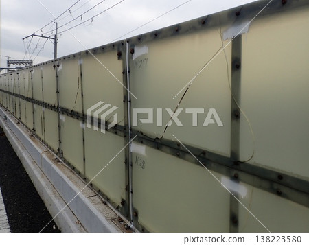 道路上老化的基礎設施在維修前,出現了開裂和變色的聚碳酸酯隔音板。 道路上老化的基礎設施在維修前,出現了開裂和變色的聚碳酸酯隔音板。 138223580