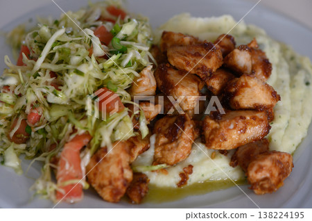 Delicious grilled chicken served on creamy mashed potatoes with fresh salad on a sunny afternoon 138224195