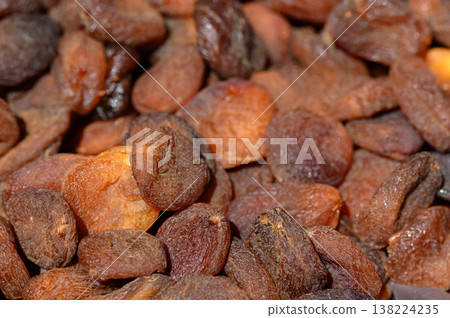 Dried apricots glimmering under warm light create a tempting treat found in vibrant markets Dried apricots glimmering under warm light create a tempting treat found in vibrant markets 138224235